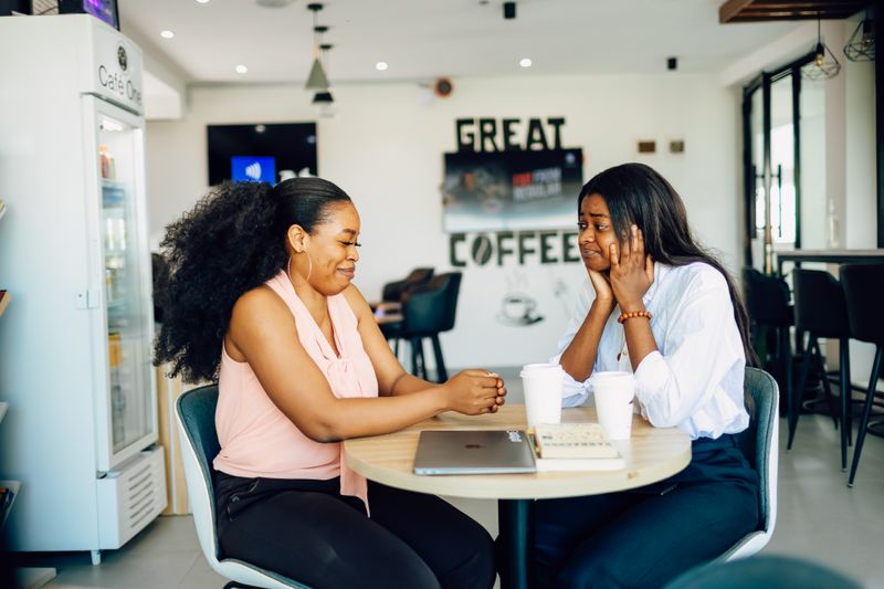 Two women talking over coffee in a Lagos café